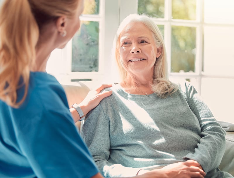 A senior woman being supported by her nurse at home